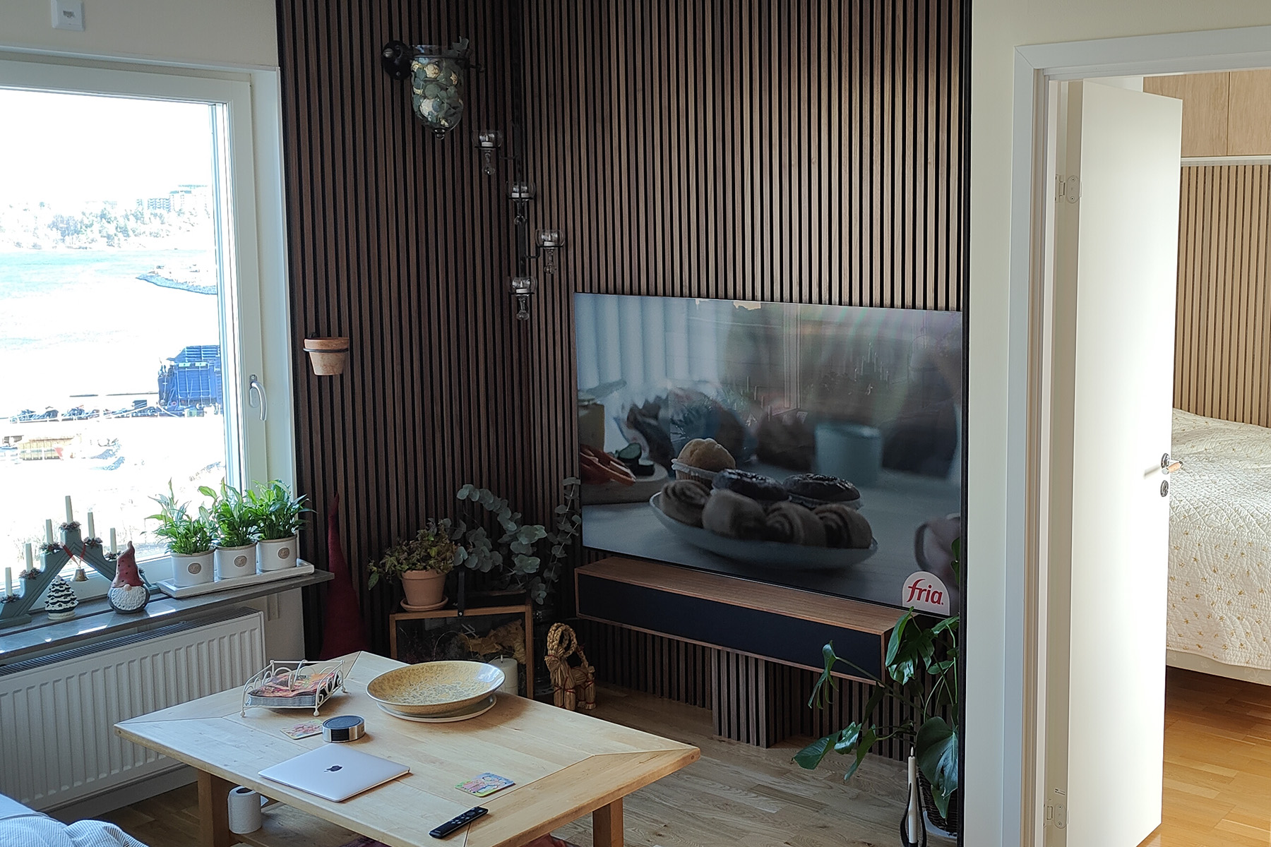 Inomhusrenovering i Stockholm – vardagsrum med träpanel och ljus inredning, exempel på Nova Byggs expertis inom tapetsering, målning och ombyggnation